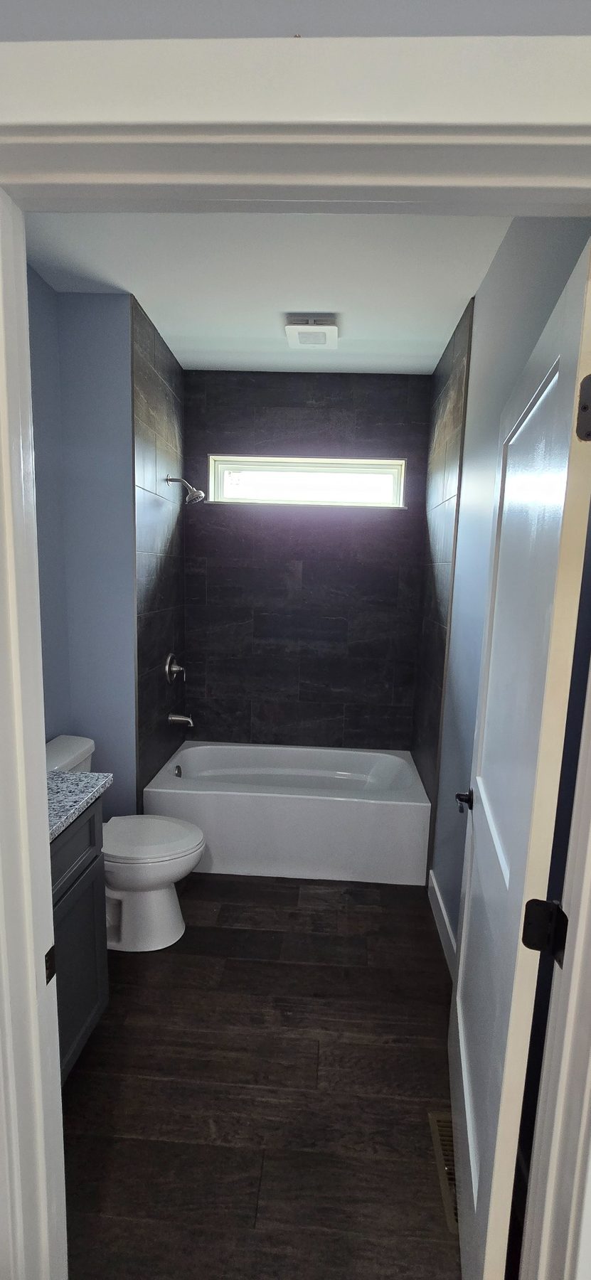 Bathroom with tub and dark tile