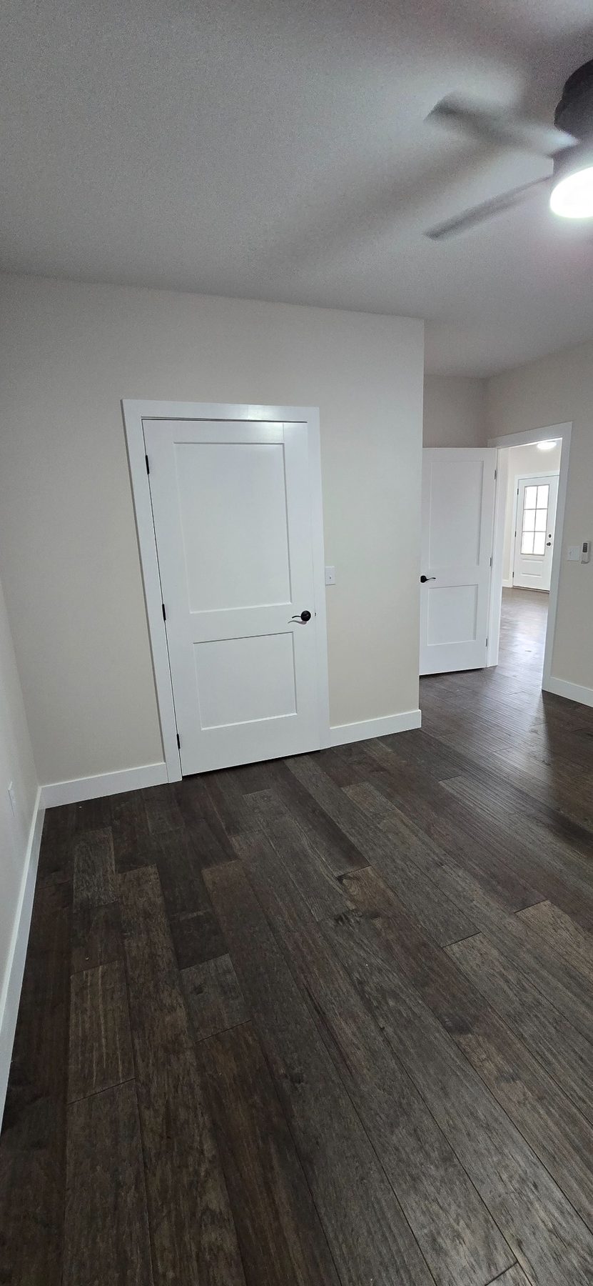 Room with white walls and dark flooring