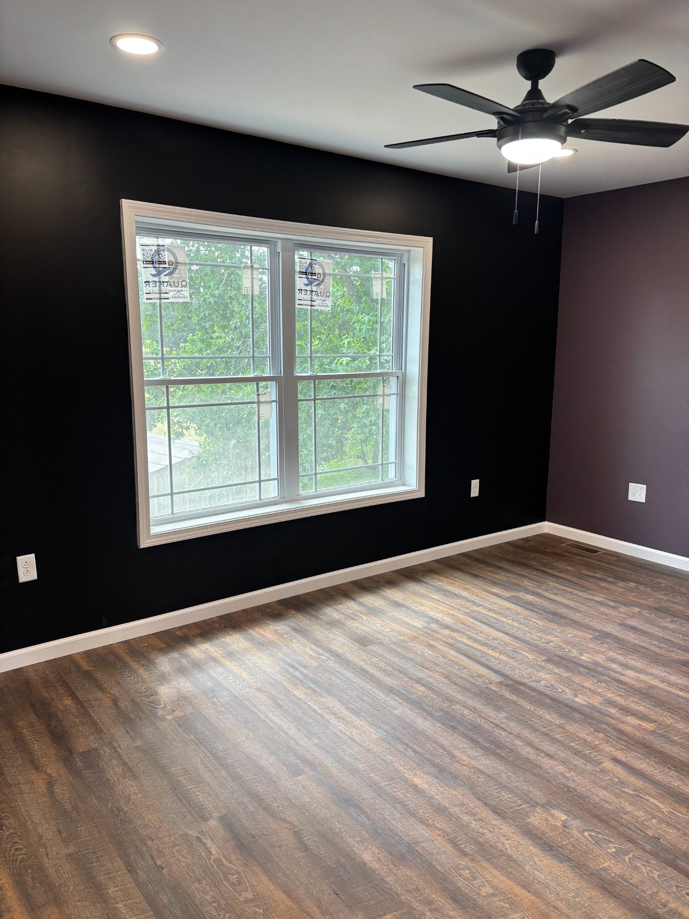 Room with dark accent wall and ceiling fan