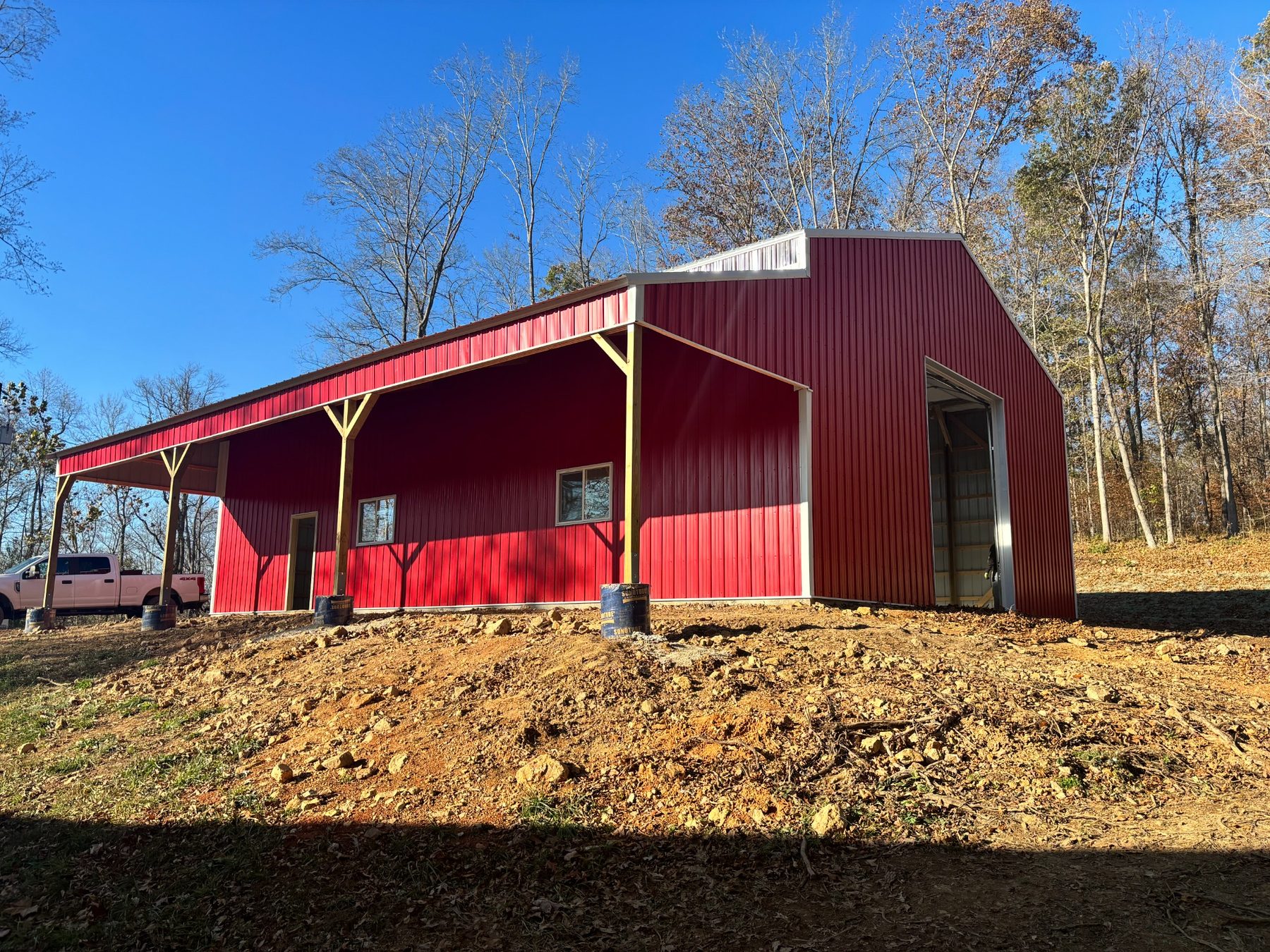 Covered side and entrance of the red metal building
